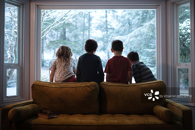孩子们望着窗外飘落的雪花图片素材