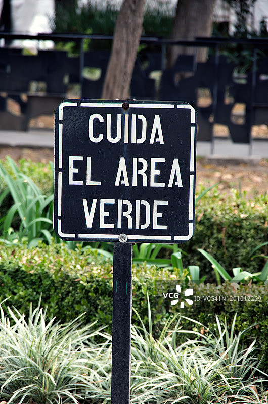 在墨西哥墨西哥城的圣安琪尔，一个公园里挂着“保护绿色区域”的牌子图片素材