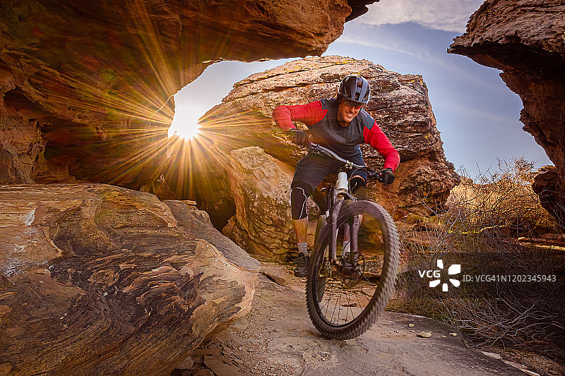 骑山地车穿过西南沙漠的巨石图片素材