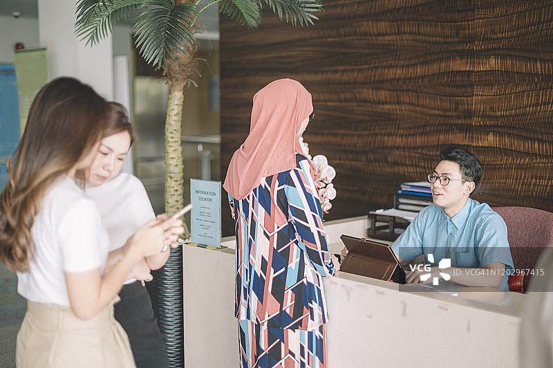 马来西亚医院的挂号柜台为客户开放，患者挂号和客户排队等候图片素材