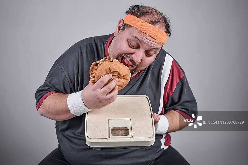 超重男子吃汉堡超过体重秤图片素材