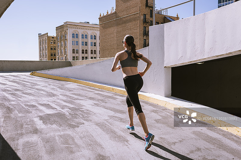 女跑步者爬上城市的停车场图片素材