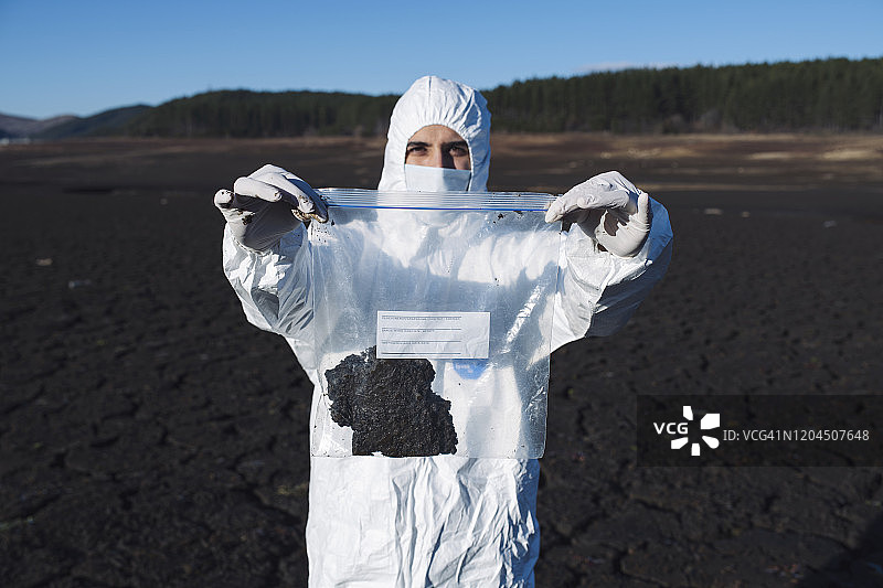 戴着防护装备检查土壤的科学家图片素材