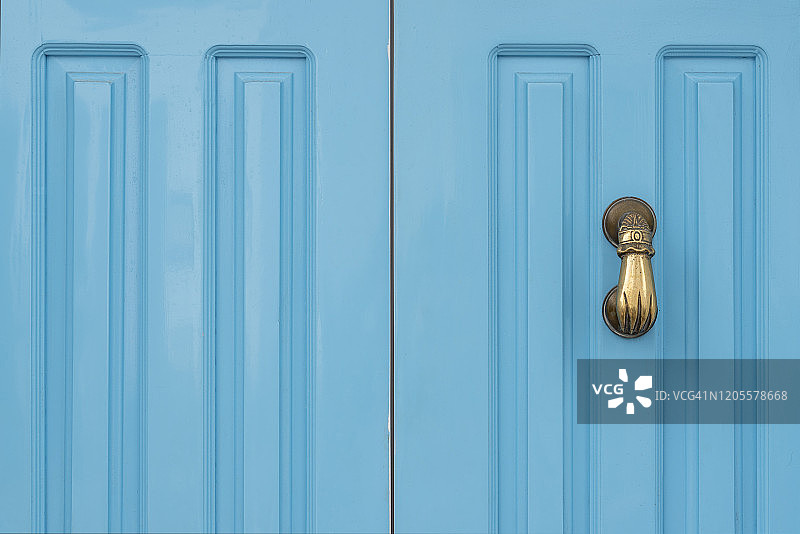 蓝色门和金色门环在一只手的形状图片素材