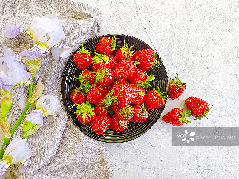 新鲜草莓在一个盘子上的混凝土背景花蝴蝶花图片素材