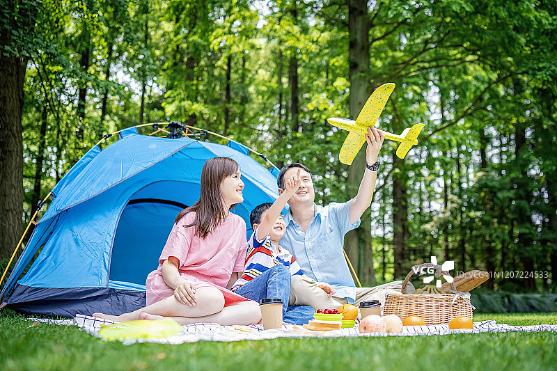 快乐的年轻家庭露营在森林图片素材