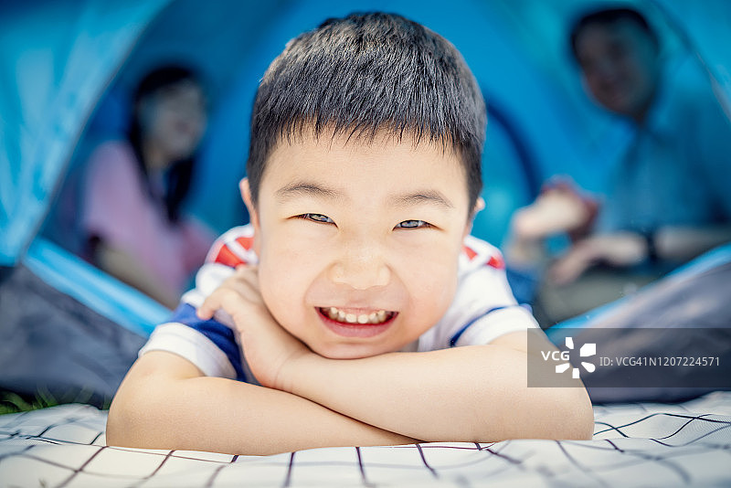 快乐可爱的男孩露营与父母在公园图片素材