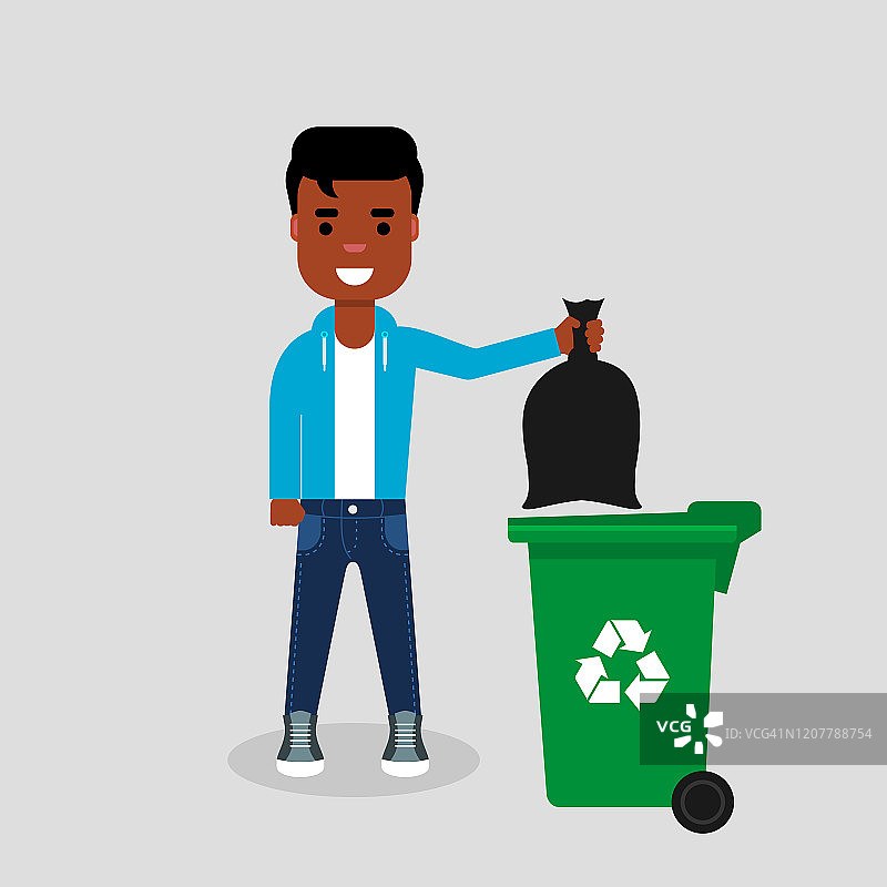年轻的非洲裔美国人穿着牛仔裤和运动衫把一个黑色的垃圾袋扔进绿色的回收箱。图片素材