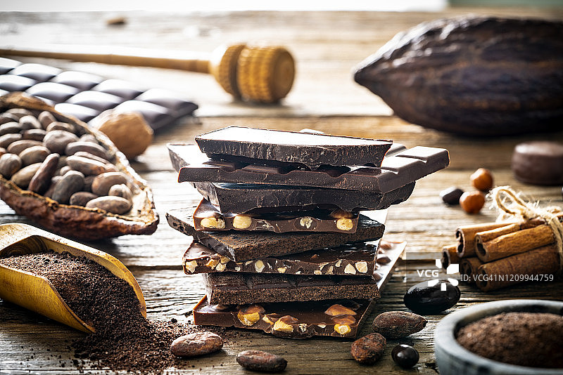 巧克力棒与坚果堆叠和可可豆粉勺图片素材