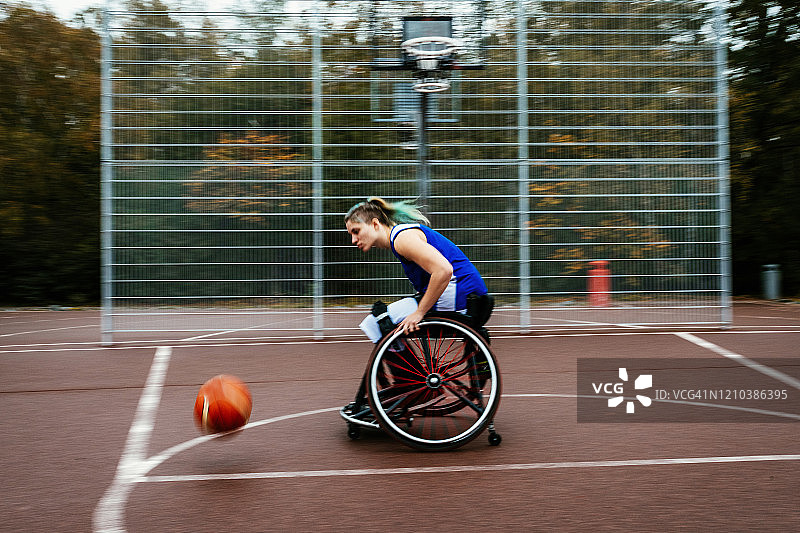 女人在轮椅上打篮球-运动模糊的照片图片素材