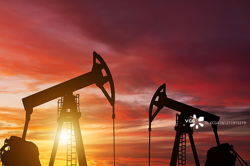 油泵在日落的背景。世界石油工业图片素材