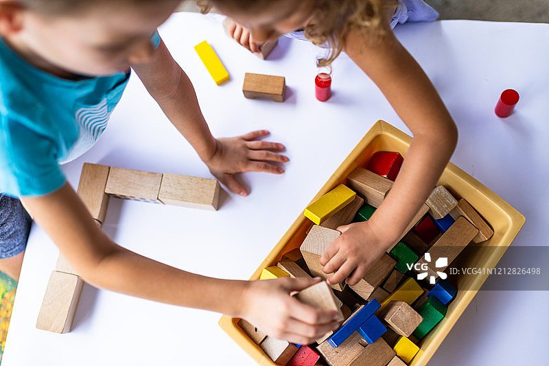一个男孩和女孩玩彩色积木的高角度视图图片素材