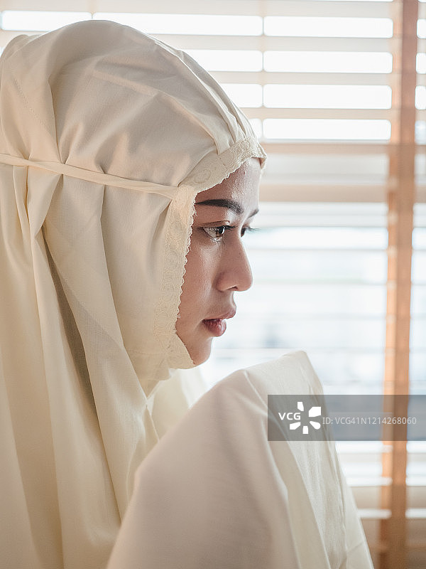 年轻的穆斯林妇女在家里祈祷图片素材