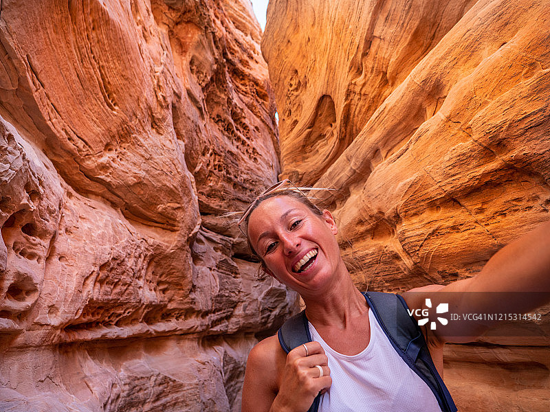 一名女子在美国火谷州立公园的狭缝峡谷中自拍图片素材