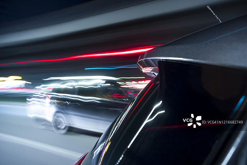 电动车在繁忙的城市夜晚行驶得很快。图片素材