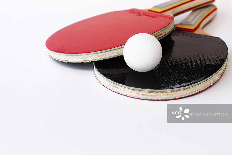 红色和黑色的球拍打乒乓球在白色的背景，俯视图，运动概念图片素材