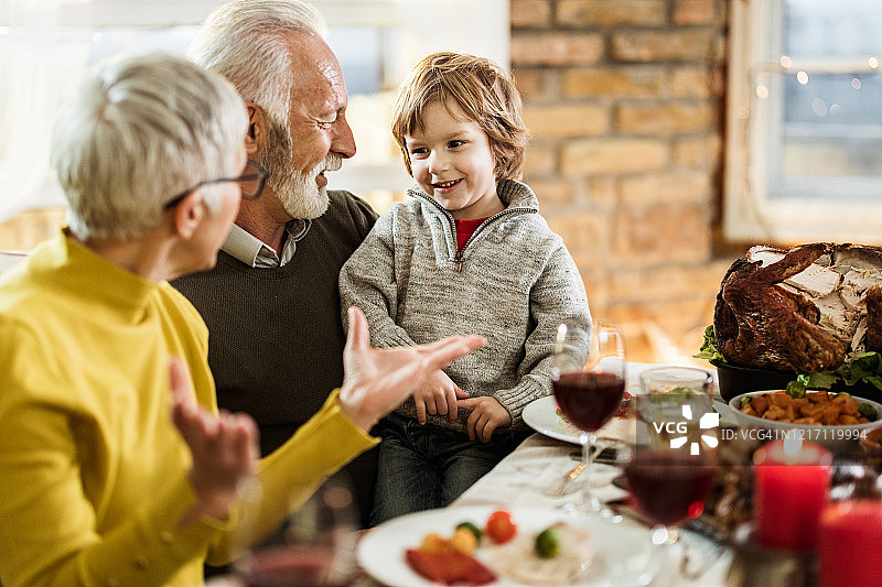 感恩节大餐时，快乐的爷爷奶奶和孙子聊天。图片素材