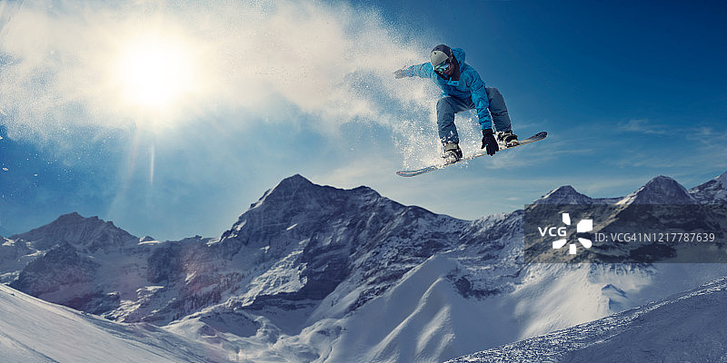 极限滑雪板在雪山大规模空中跳跃图片素材