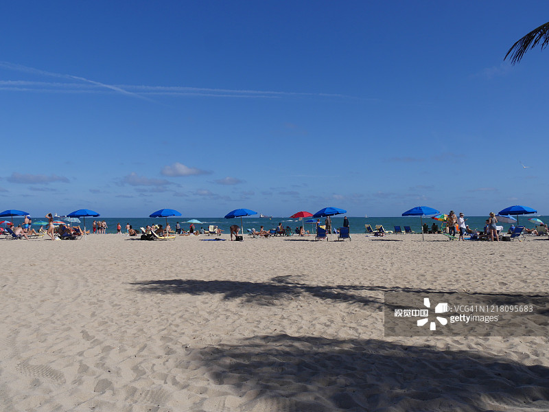 迈阿密海滩的广角镜头，海滩游客散布在白色的沙滩上。图片素材