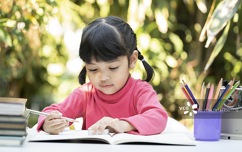 亚洲学龄前儿童在家里做作业。教育与学习理念图片素材