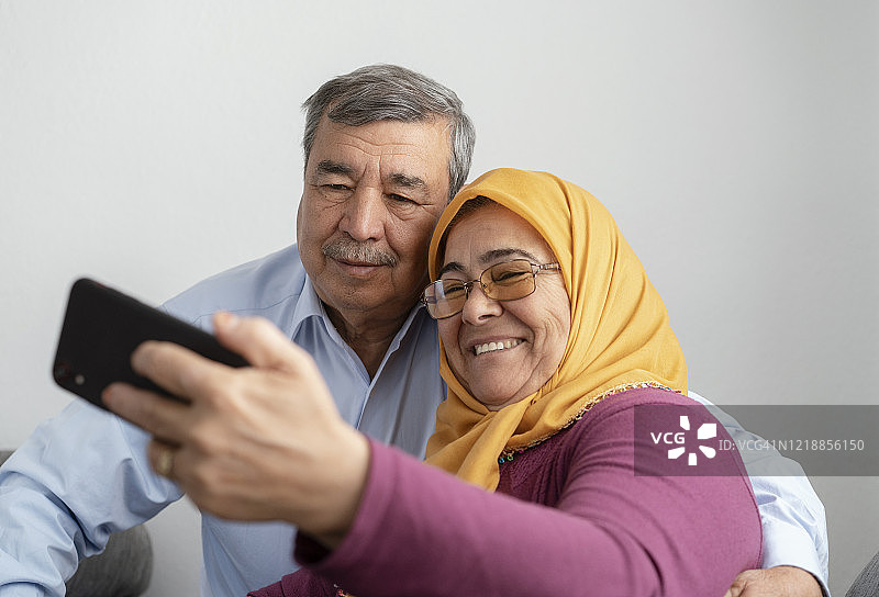 老年夫妇使用智能手机，在家里进行视频通话图片素材