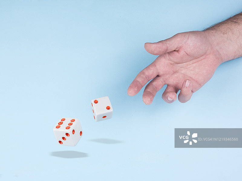 掷骰子游戏:手掷方块游戏，孤立在明亮的蓝色背景图片素材