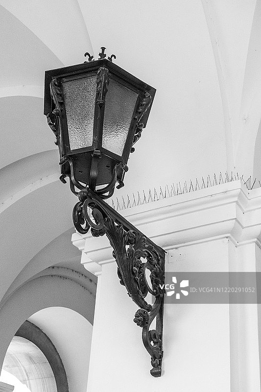 白墙上挂着一盏古老的街灯;黑白图像图片素材