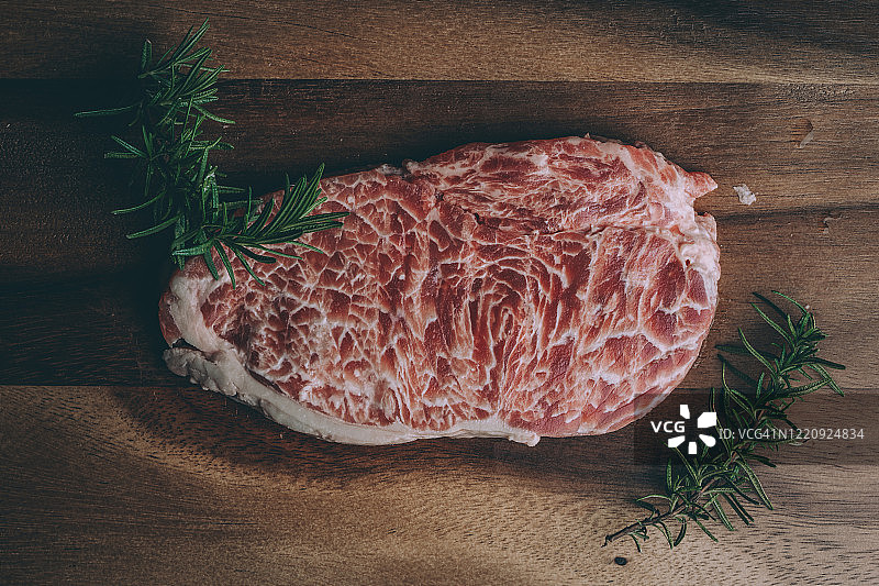 用切肉刀和调味料放在木板上的生肋眼牛排图片素材