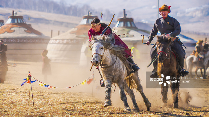 穿着传统服饰骑马的蒙古人来自蒙古国的蒙古村。与风景秀丽的蒙古山。图片素材