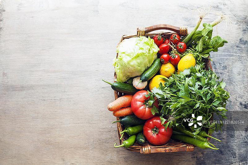 蔬菜在篮子里，有机蔬菜在木制的背景上图片素材