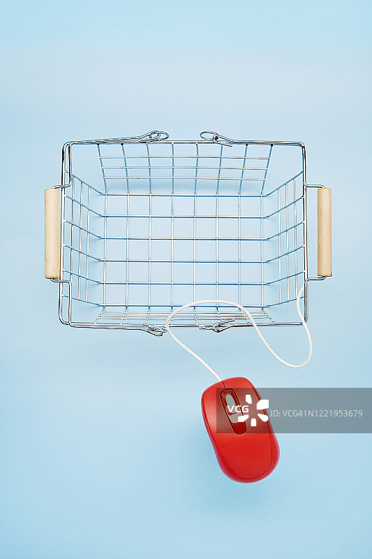 高角度的空购物篮和红色鼠标在蓝色背景，网上购物图片素材