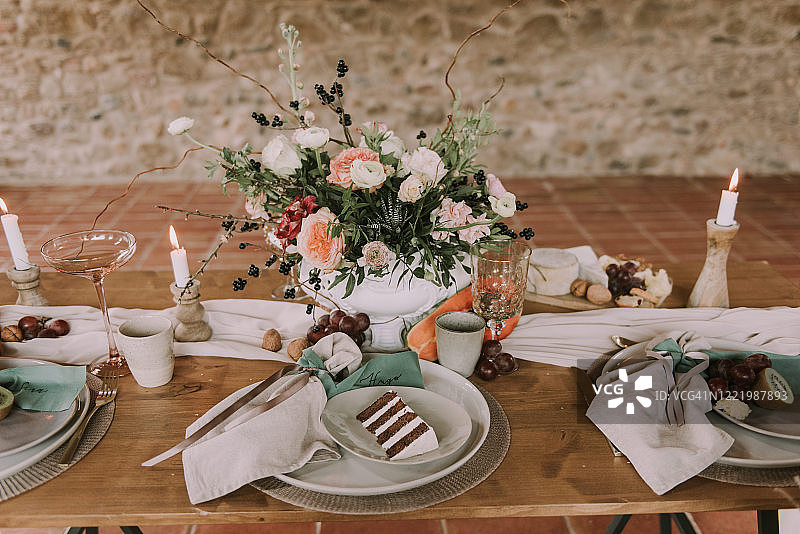 一块婚礼蛋糕放在装饰着鲜花的桌子上图片素材