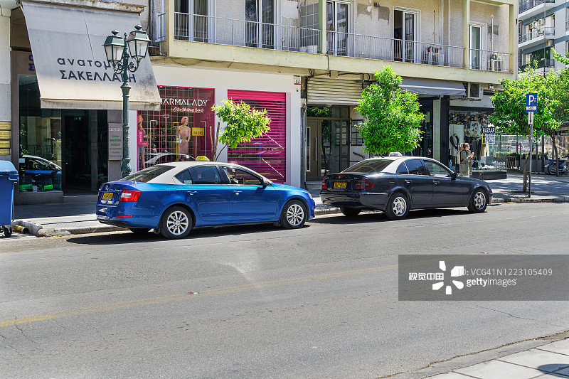 蓝色和白色的出租车和司机，停在的士站，在Mitropoleos街。图片素材