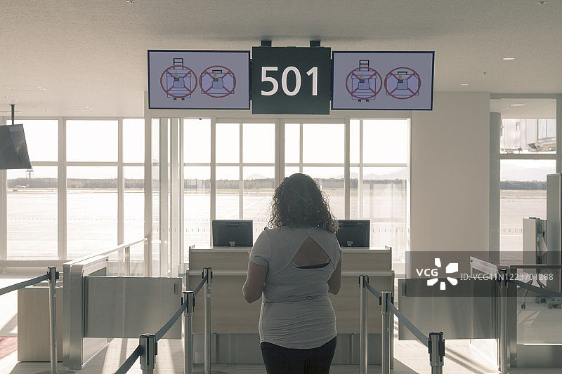 年轻游客独自在机场候机室等候图片素材