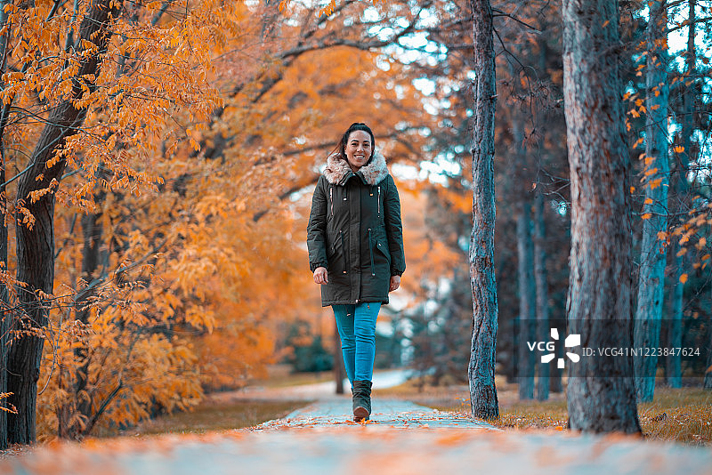 一个在秋天散步的女人的肖像图片素材