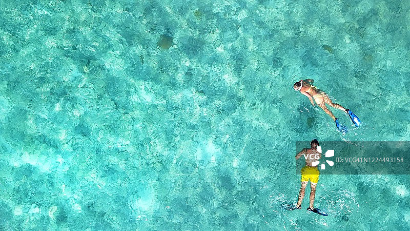 一对男女一起浮潜，穿过马尔代夫环礁透明的海水图片素材