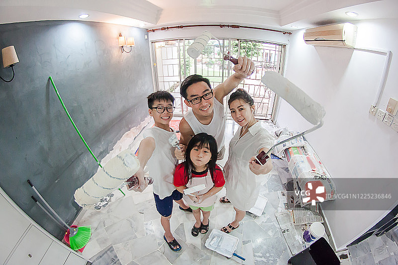 一个快乐的家庭在镜头前画着他们的新房子图片素材