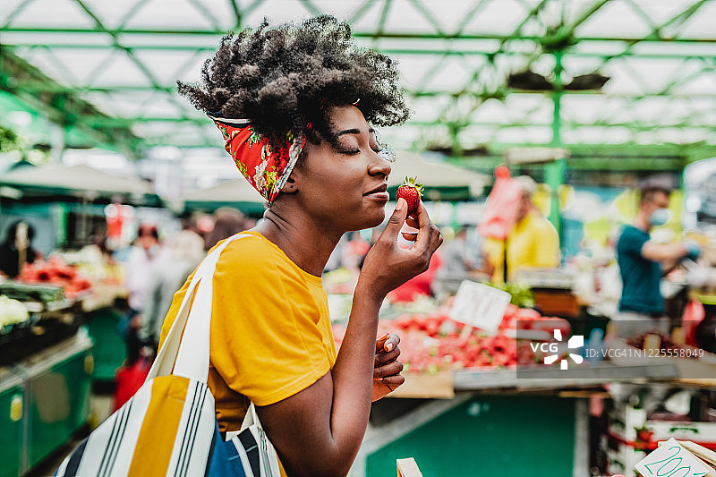年轻的非洲妇女在市场上买水果图片素材