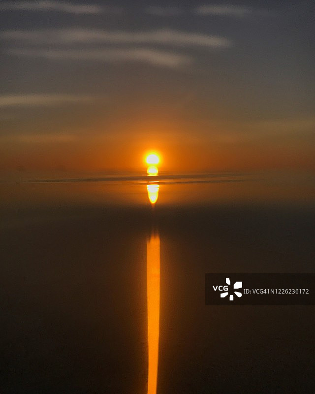 黎明时分，一束长长的阳光穿过海洋图片素材
