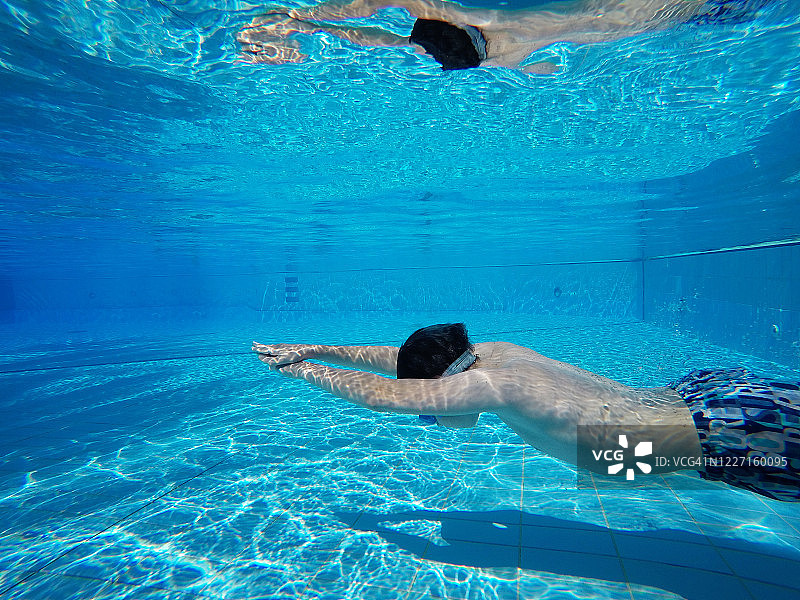 小男孩游泳池的水玩暑假的乐趣图片素材