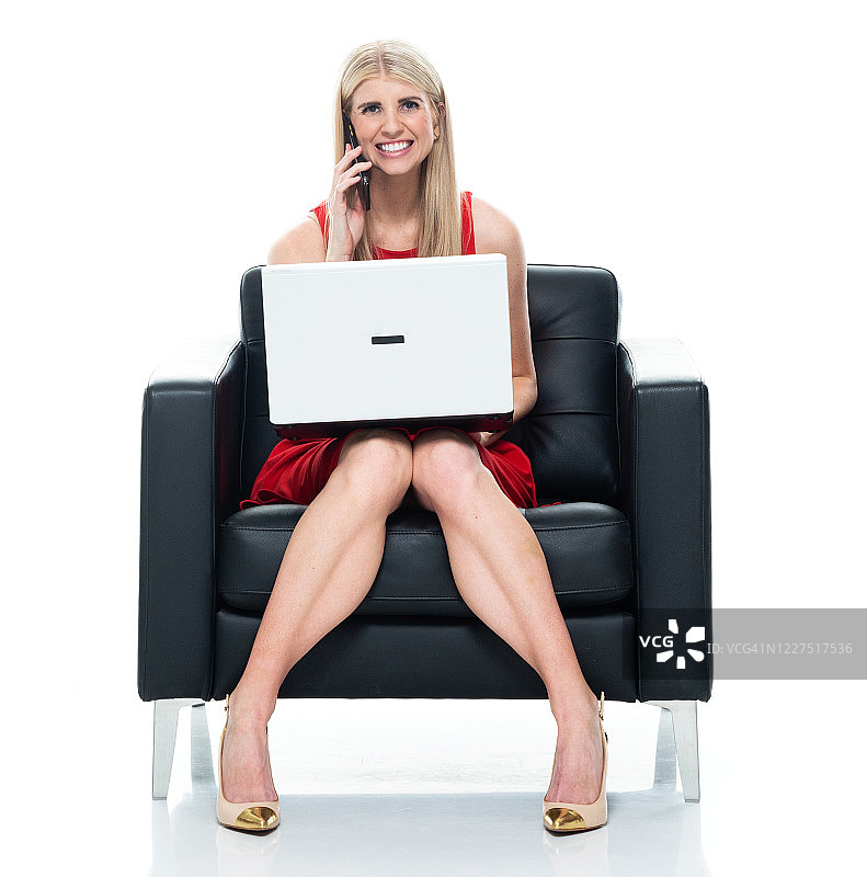 白人年轻女性在白色背景前休息，使用笔记本电脑图片素材