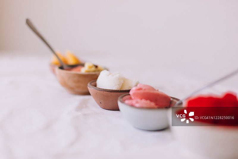 不同口味和颜色的小碗自制冰淇淋排成一排图片素材