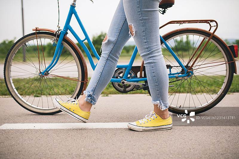 女人骑着蓝色复古城市自行车的特写图片素材
