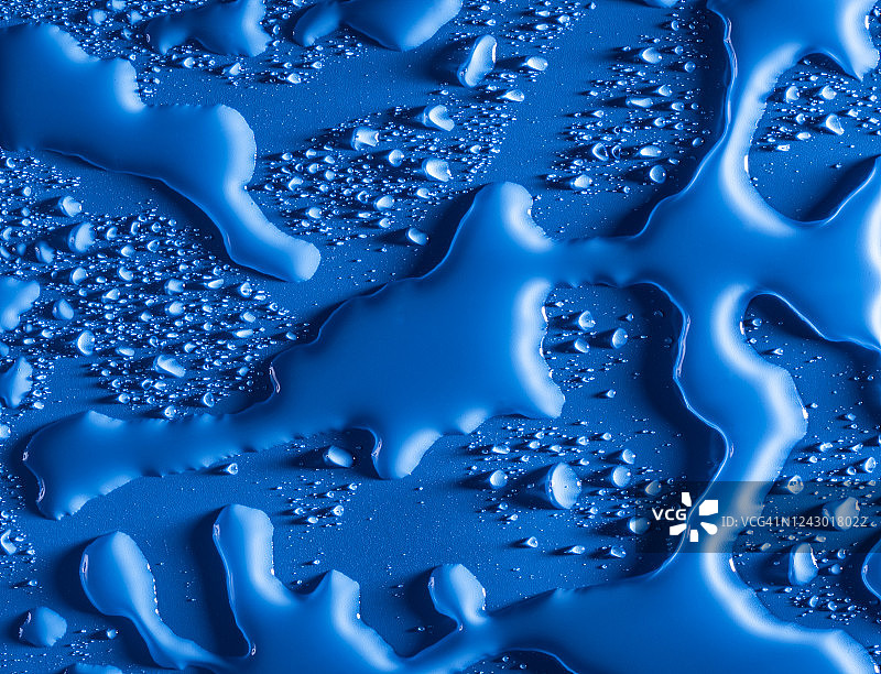 由蓝色背景上的气泡和水滴形成的纹理的完整框架。图片素材