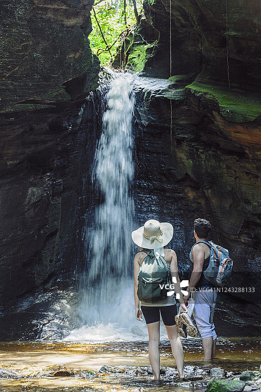 一对年轻夫妇正沿着巴西的一条山间河流峡谷图片素材