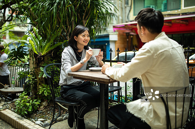 年轻的台湾情侣在户外咖啡厅浪漫约会图片素材