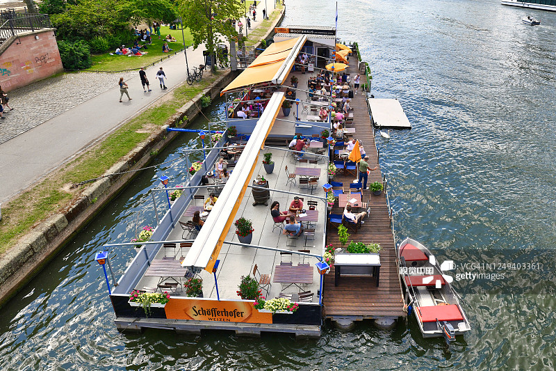 法兰克福，德国，在法兰克福的主要河上，一艘名为“Bootshaus”的船上的餐馆和游客图片素材