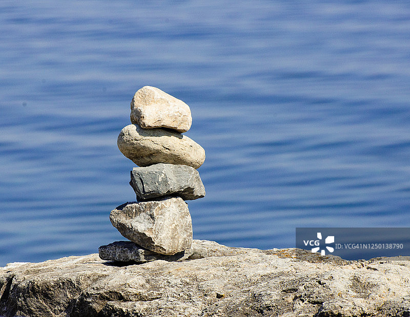 平衡禅宗岩石旁边的湖图片素材