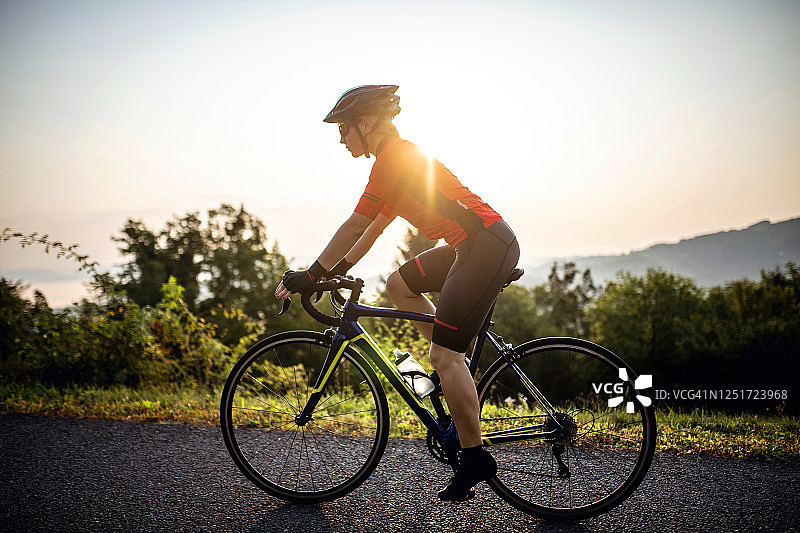 年轻女性骑自行车上山的肖像图片素材