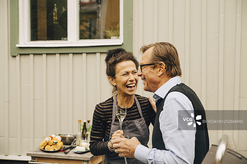 在聚会期间，老男人和老女人在后院喝酒时大笑图片素材